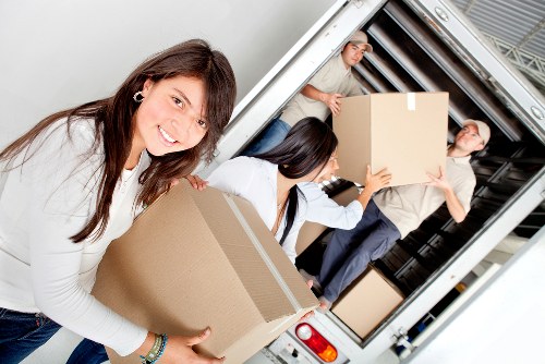 Removal team carrying boxes through a typical East London apartment building